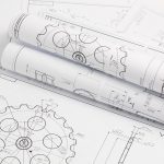 paper engineering drawings of industrial parts and mechanisms